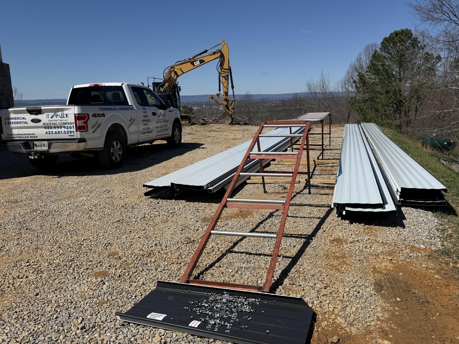 Metal roofing panels being lifted to a commercial jobsite roof