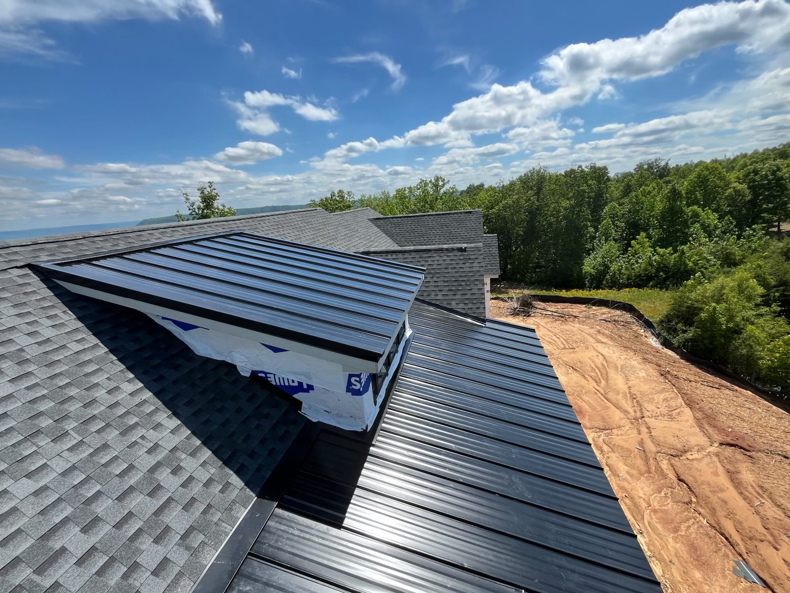 Newly shingled roof ridge against a clear Chattanooga sky