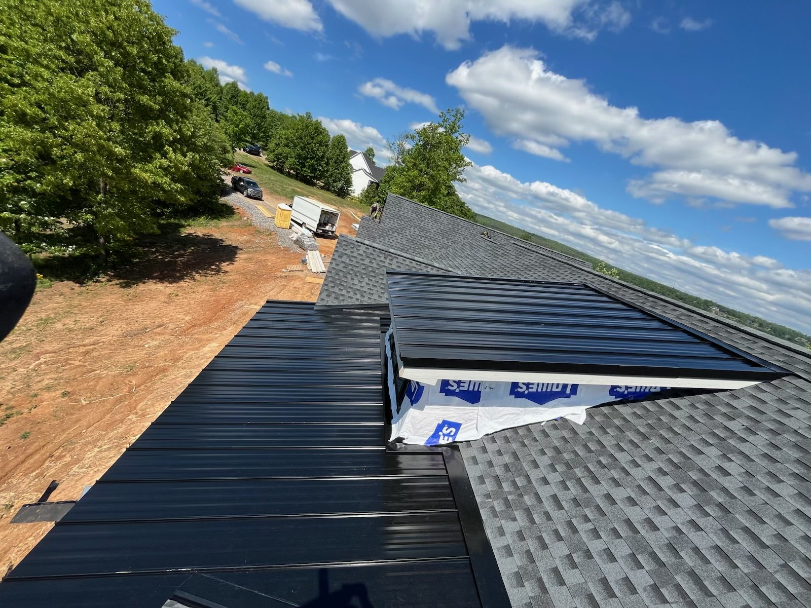 Dark standing-seam metal roof with skylight installed by HB Contracting